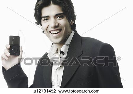 Portrait of a young man holding an MP3 player View Large Photo Image Stock Image - Portrait of a young man holding an MP3 player. Fotosearch