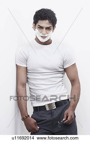 Portrait of a young man with shaving cream on his face leaning against a wall View Large Photo Image Picture - Portrait of a young man with shaving cream on his face leaning against a wall. Fotosearch
