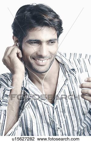 Young man listening to an MP3 Player View Large Photo Image Stock Image - Young man listening to an MP3 Player. Fotosearch
