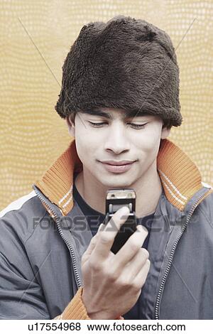 Stock Photo - Close-up of a young man holding a mobile phone. Fotosearch