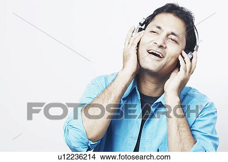 Picture - Close-up of a young man listening to music. Fotosearch