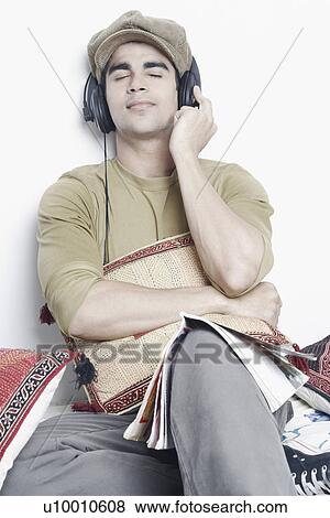Stock Photo - Close-up of a young man listening to music wearing headphones. Fotosearch