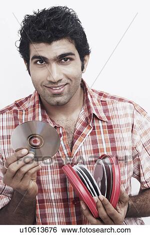 Portrait of a young man holding CDs and smiling View Large Photo Image Stock Photograph - Portrait of a young man holding CDs and smiling. Fotosearch