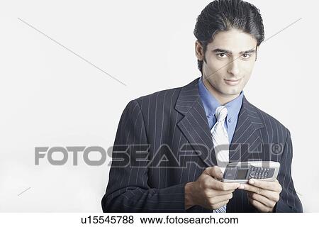 Stock Photo - Portrait of a young man operating a mobile phone. Fotosearch