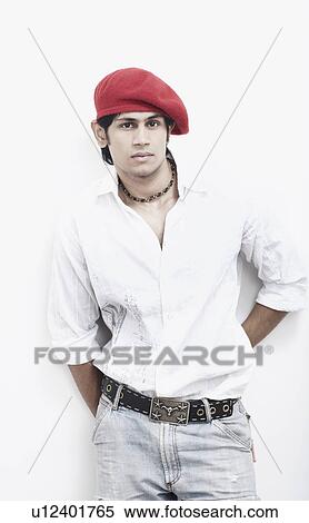 Portrait of a young man standing with his hands behind his back View Large Photo Image Stock Photography - Portrait of a young man standing with his hands behind his back. Fotosearch