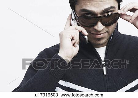 Stock Image - Portrait of a young man talking on a mobile phone. Fotosearch