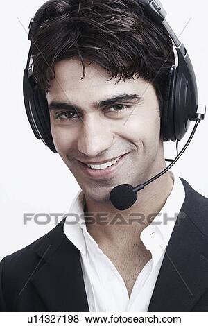 Stock Photo - Portrait of a young man wearing a headset. Fotosearch