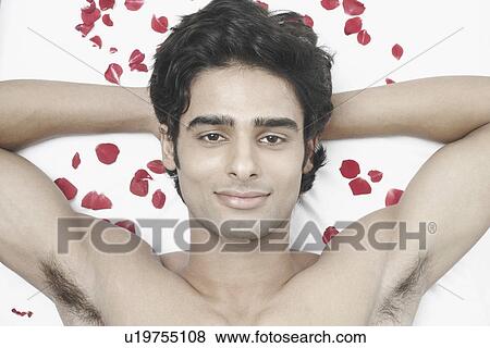Stock Photo - Portrait of a young man with his hand behind his head. Fotosearch