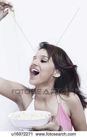 Close-up of a young woman eating noodles from a bowl View Large Photo Image Stock Image - Close-up of a young woman eating noodles from a bowl. Fotosearch