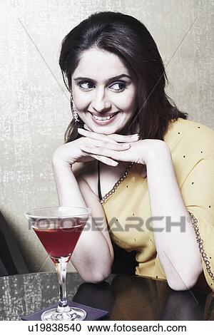 Close-up of a young woman in front of a martini glass View Large Photo Image Stock Image - Close-up of a young woman in front of a martini glass. Fotosearch