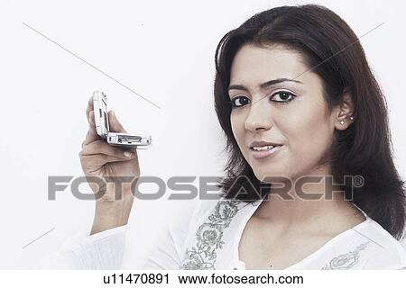 Stock Image - Portrait of a young woman holding a mobile smiling. Fotosearch
