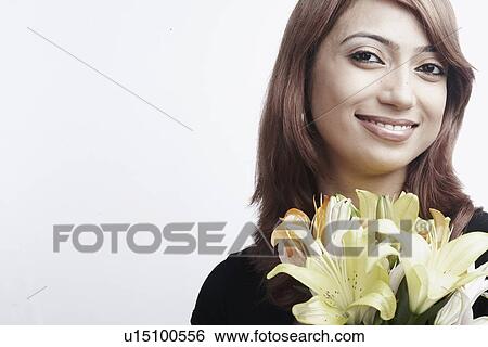 Stock Photograph - Portrait of a young woman holding a bouquet of flowers. Fotosearch