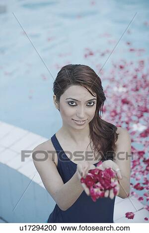 Portrait of a young woman holding rose petals in her palm View Large Photo Image Stock Image - Portrait of a young woman holding rose petals in her palm. Fotosearch