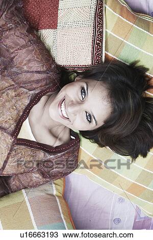 Portrait of a young woman lying on her back smiling View Large Photo Image Stock Image - Portrait of a young woman lying on her back smiling. Fotosearch