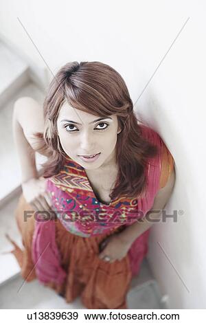 Portrait of a young woman standing on stairs View Large Photo Image Stock Photo - Portrait of a young woman standing on stairs. Fotosearch