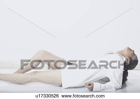 Stock Photograph - Side profile of a young woman lying down. Fotosearch