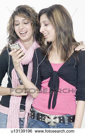 Two young women listening to an MP3 Player View Large Photo Image Stock Photograph - Two young women listening to an MP3 Player. Fotosearch