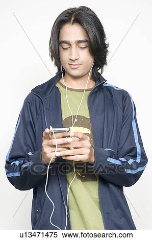Close-up of a young man listening to an MP3 Player View Large Photo Image Stock Photography - Close-up of a young man listening to an MP3 Player. Fotosearch