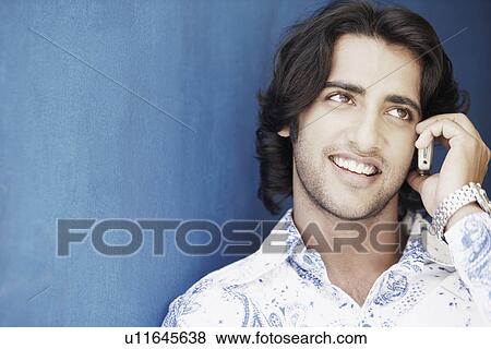 Stock Photo - Close-up of a young man talking on a mobile phone. Fotosearch