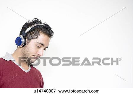 Stock Photo - Close-up of a young man wearing headphones. Fotosearch