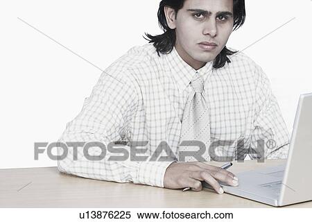 Stock Photography - Portrait of a businessman sitting in front of a laptop. Fotosearch