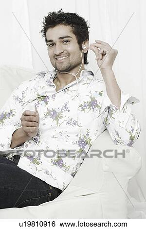 Portrait of a young man listening to an MP3 player View Large Photo Image Stock Photograph - Portrait of a young man listening to an MP3 player. Fotosearch