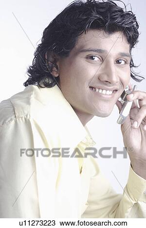 Stock Image - Portrait of a young man talking on a mobile phone. Fotosearch