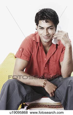 Portrait of a young man talking on a mobile phone View Large Photo Image Stock Photo - Portrait of a young man talking on a mobile phone. Fotosearch