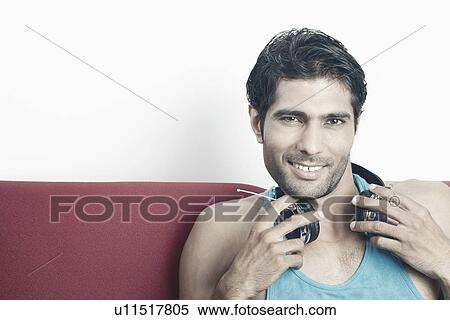Stock Photography - Portrait of a young man with headphones around his neck. Fotosearch