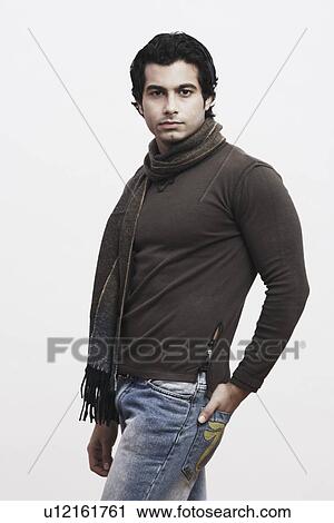 Stock Image - Portrait of a young man with his hands in his pockets. Fotosearch