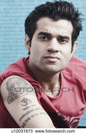 Portrait of a young man with tattoos on his arm View Large Photo Image Stock Image - Portrait of a young man with tattoos on his arm. Fotosearch