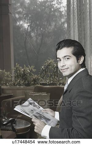 Side profile of a businessman holding a newspaper View Large Photo Image Picture - Side profile of a businessman holding a newspaper. Fotosearch