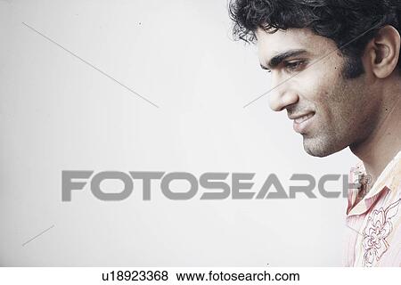 Side profile of a young man smiling View Large Photo Image Stock Photo - Side profile of a young man smiling. Fotosearch