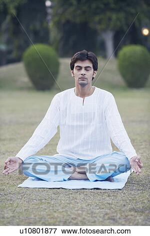 Stock Photo - Young man meditating in the lotus position. Fotosearch