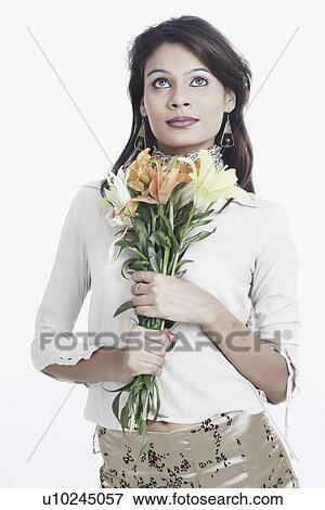 Stock Photo - Close-up of a young woman holding a bunch of flowers. Fotosearch