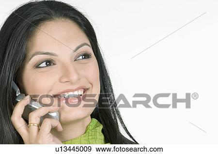 Stock Photo - Close-up of a young woman talking on a mobile phone. Fotosearch