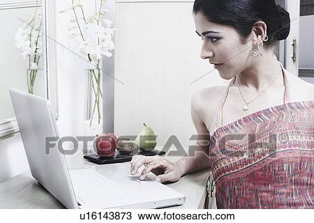 Stock Image - Close-up of a young woman using a laptop. Fotosearch