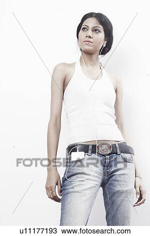 Low angle view of a young woman listening to an MP3 player View Large Photo Image Stock Image - Low angle view of a young woman listening to an MP3 player. Fotosearch