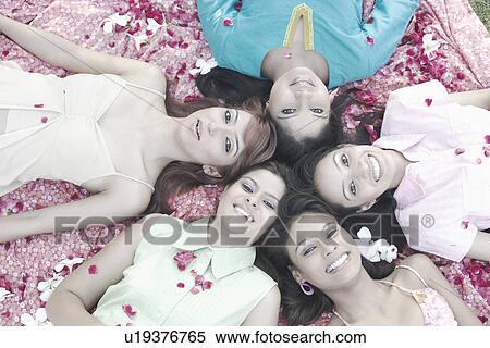 Stock Photography - Portrait of a teenage girl and four young women lying on their back. Fotosearch