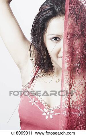 Stock Image - Portrait of a young woman covering her face with a veil. Fotosearch