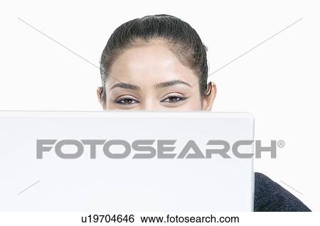 Portrait of a young woman sitting in front of a laptop View Large Photo Image Stock Photograph - Portrait of a young woman sitting in front of a laptop. Fotosearch