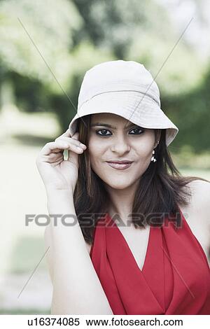 Portrait of a young woman wearing a hat smiling View Large Photo Image Stock Photography - Portrait of a young woman wearing a hat smiling. Fotosearch