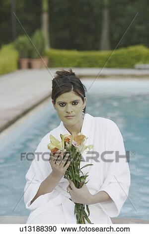 Portrait of a young woman with a facial mask on the edge of a swimming pool View Large Photo Image Stock Image - Portrait of a young woman with a facial mask on the edge of a swimming pool. Fotosearch