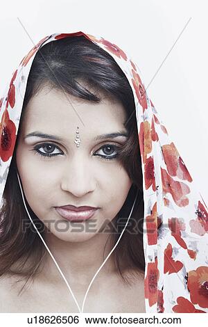Portrait of a young woman with a stole on her head wearing headphones View Large Photo Image Stock Photograph - Portrait of a young woman with a stole on her head wearing headphones. Fotosearch