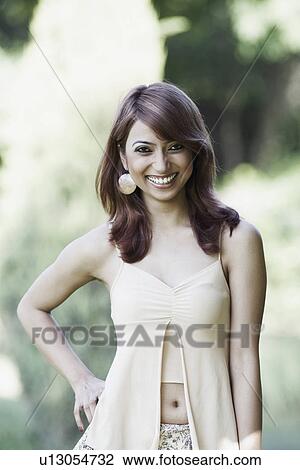 Stock Image - Portrait of a young woman with arms akimbo. Fotosearch