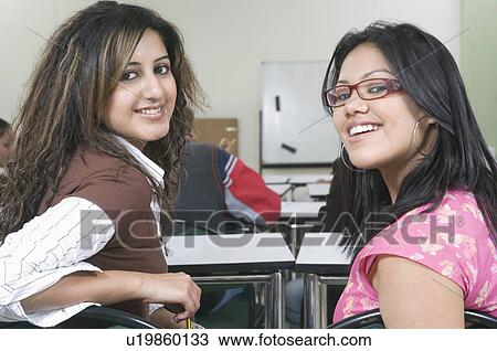 Portrait of two young women in a classroom View Large Photo Image Stock Image - Portrait of two young women in a classroom. Fotosearch