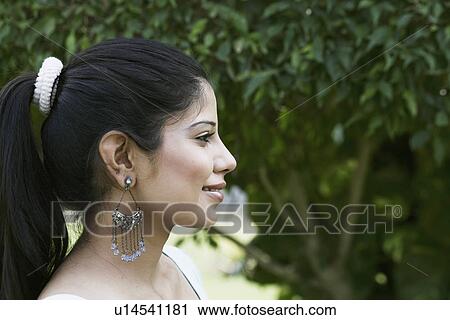 Side profile of a young woman smiling View Large Photo Image Stock Image - Side profile of a young woman smiling. Fotosearch