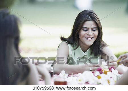 Young woman holding a flower View Large Photo Image Stock Photo - Young woman holding a flower. Fotosearch