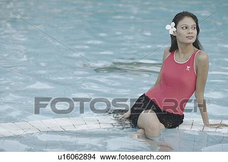 Picture - Young woman sitting in a swimming pool. Fotosearch