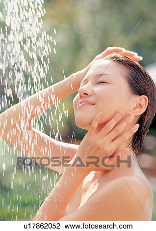Stock Image - Woman taking an outdoor shower. Fotosearch